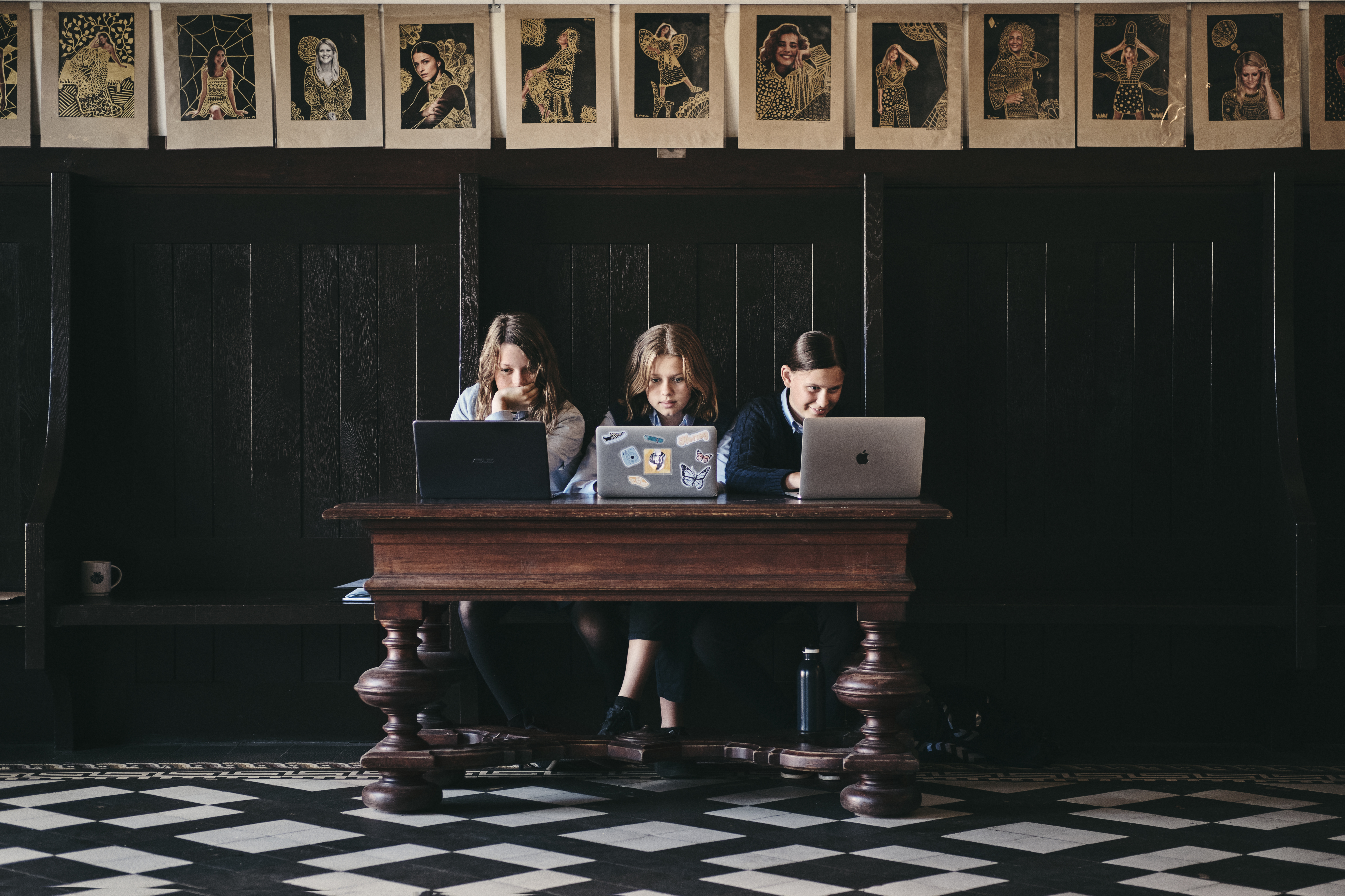 Tre elever sidder og laver lektier på en bænk på Herlufsholm